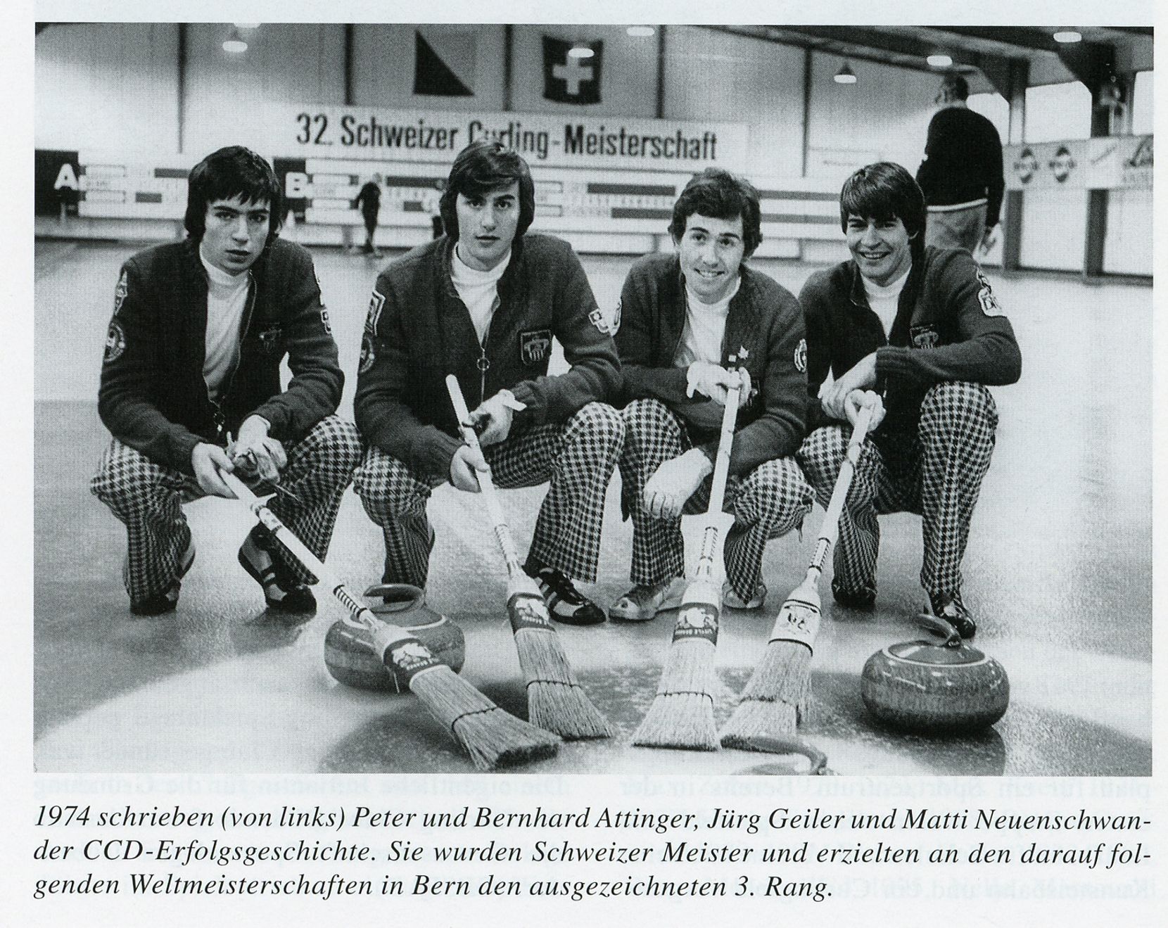 Vier Curler posieren mit Steinen und Besen für ein Foto. 